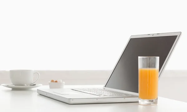 Ordenador portátil moderno y elegante en una mesa, mientras que la hora del desayuno —  Fotos de Stock