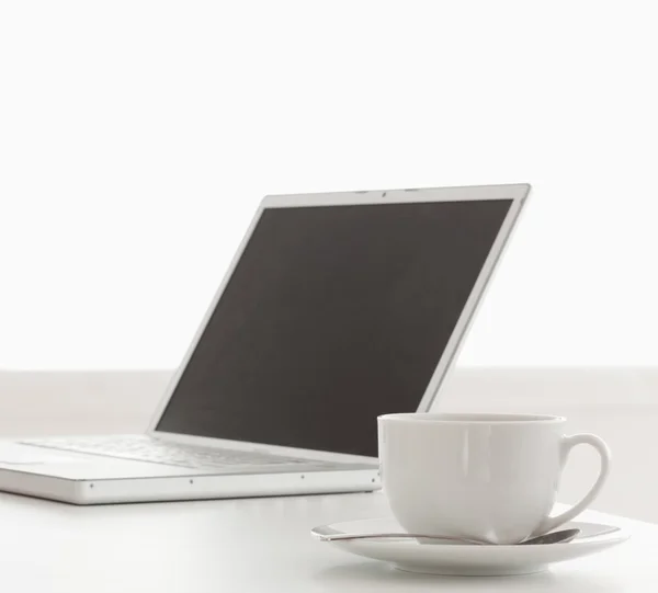 现代笔记本电脑和杯茶在表上 — 图库照片