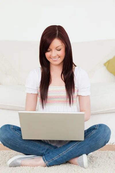 Гарний вигляд жінка розслабляється зі своїм ноутбуком, сидячи на a — стокове фото
