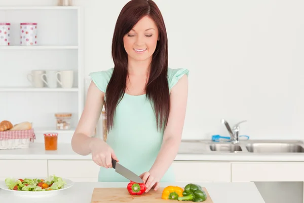有吸引力的红头发女人在 kitch 切割一些蔬菜 — 图库照片