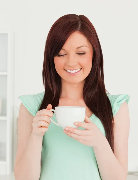 Mulher de cabelos vermelhos atraente tendo seu café da manhã na cozinha — Fotografia de Stock