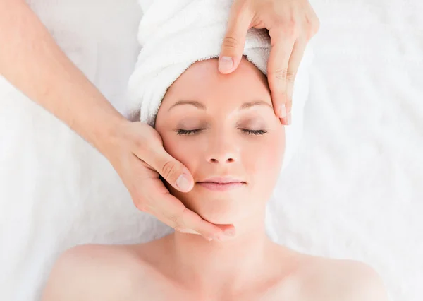 Close-up de uma mulher de cabelos vermelhos atraente recebendo uma massagem em — Fotografia de Stock
