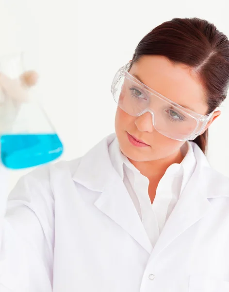 Hermoso científico sosteniendo un vaso de precipitados en un laboratorio — Foto de Stock