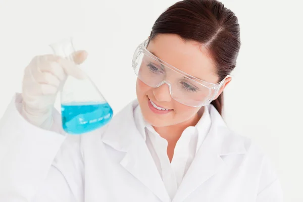 Cientista bonito segurando um copo em um laboratório — Fotografia de Stock