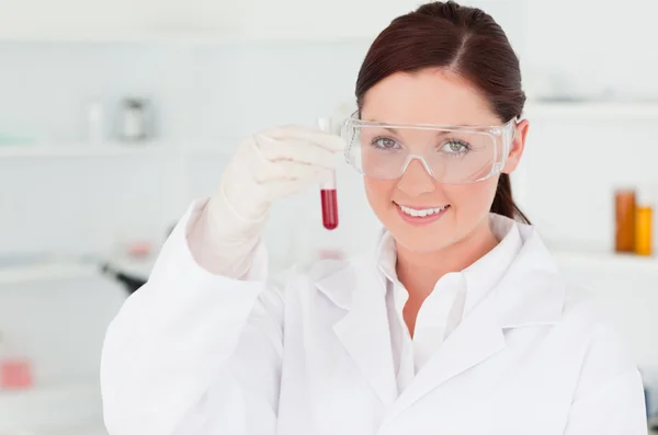 Gorgeous scientist looking at the camera while holding a test t — Stock Photo, Image