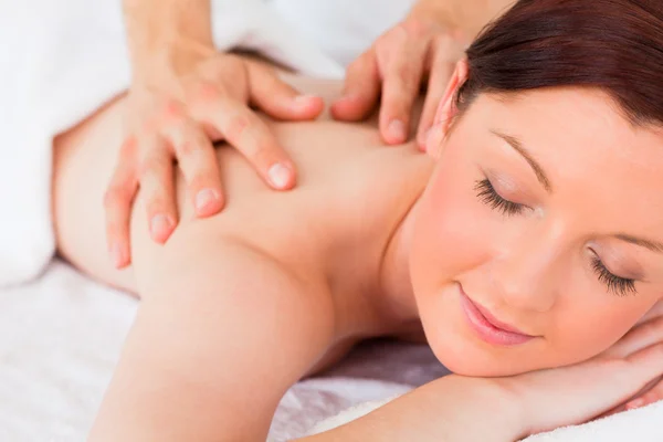 Primer plano de una hermosa mujer pelirroja recibiendo un masaje en un —  Fotos de Stock