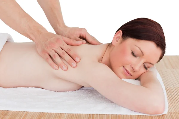 Primo piano di una affascinante donna dai capelli rossi che riceve un massaggio in un — Foto Stock