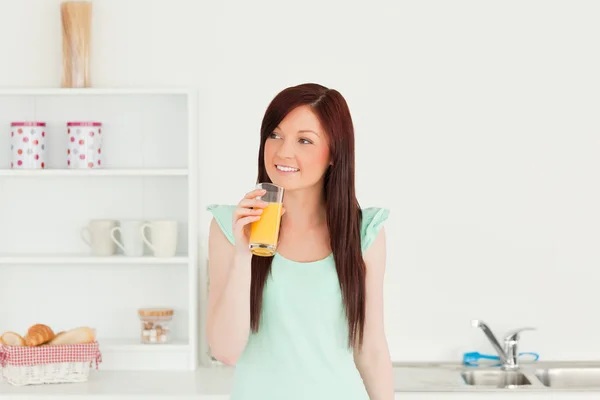 Bra rödhårig kvinna njuter av ett glas apelsin juice jag — Stockfoto