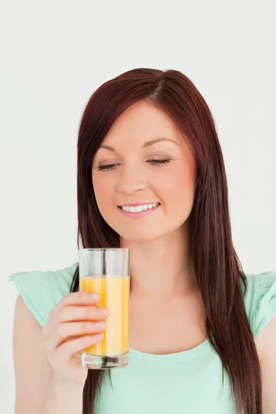 Великолепная рыжая женщина наслаждается стаканом апельсинового сока в й — стоковое фото