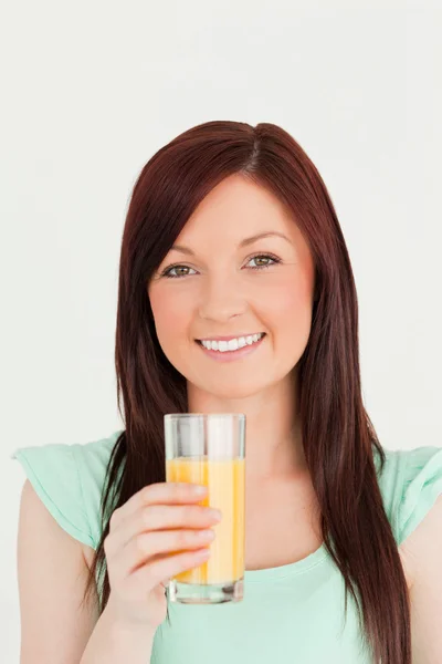 Χαρούμενα κοκκινομάλλης γυναίκα, απολαμβάνοντας ένα ποτήρι χυμό πορτοκαλιού σε ου — Φωτογραφία Αρχείου