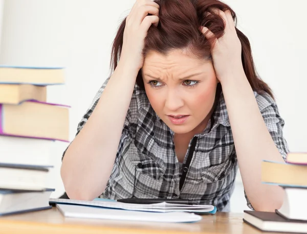 Attraente donna dai capelli rossi essere sconvolto mentre si studia per una e — Foto Stock