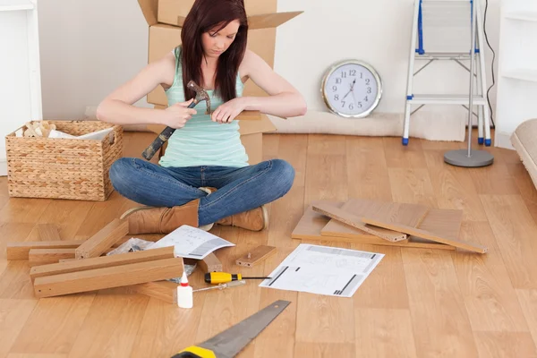 Beautiful red-haired girl using a hammer for diy at home — Stock Photo, Image