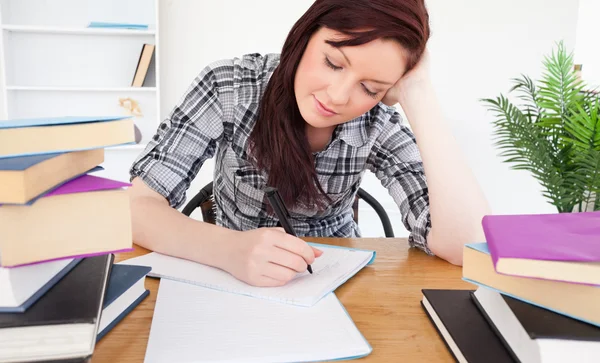 Atractiva mujer pelirroja estudiando en su escritorio —  Fotos de Stock