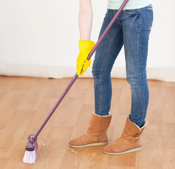 Attraente donna dai capelli rossi spazzare il pavimento a casa — Foto Stock