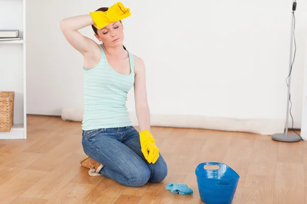 Pretty red-haired woman having a break while cleaning the floor — Stock Photo, Image