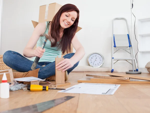 Good looking red-haired female nailing a plank at home — Stock Photo, Image