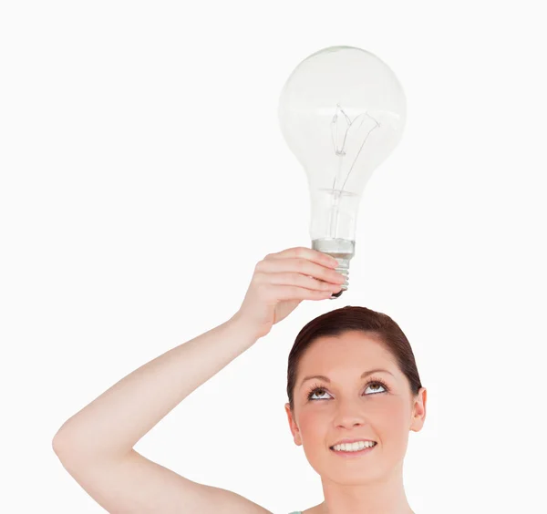 Nádherná zrzavý žena držící žárovky stoje — Stock fotografie