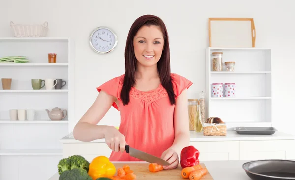 Schöne rothaarige Frau beim Gemüseschneiden in der Küche — Stockfoto