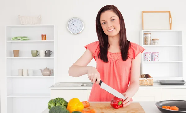 Mujer de pelo rojo bien parecido cortar algunas verduras en el kit —  Fotos de Stock