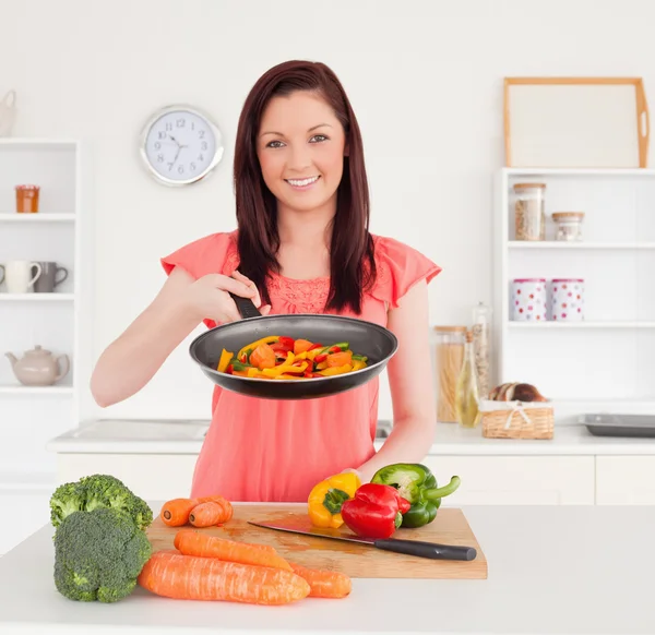 Linda mulher ruiva cozinhar legumes na cozinha — Fotografia de Stock