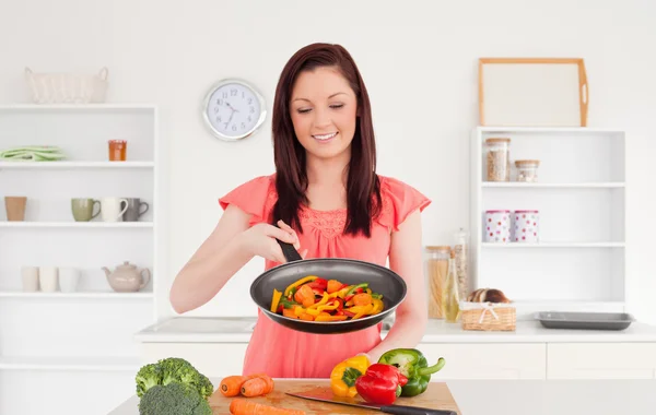 Bella donna dai capelli rossi che cucina verdure in cucina — Foto Stock