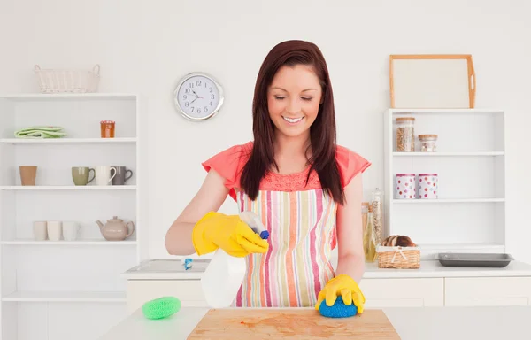 Jolie femme rousse qui nettoie une planche à découper dans la cuisine — Photo