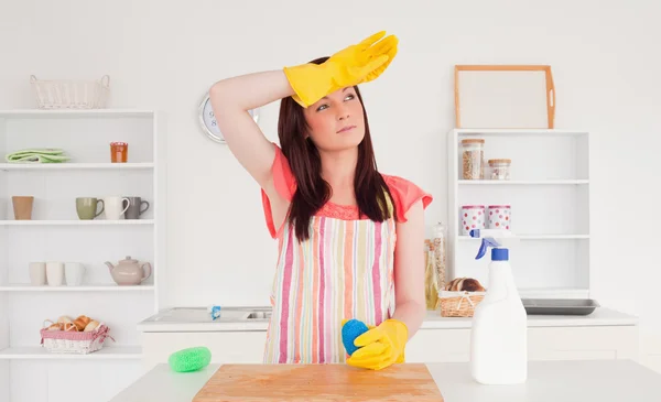 Pretty red-haired woman posing while cleaning a cutting board in — Stock Photo, Image