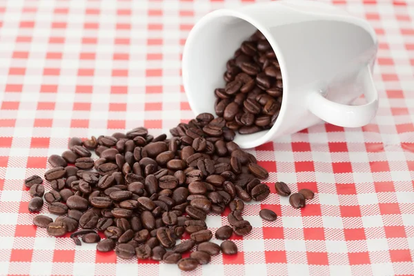 Spilled cup of coffee beans — Stock Photo, Image