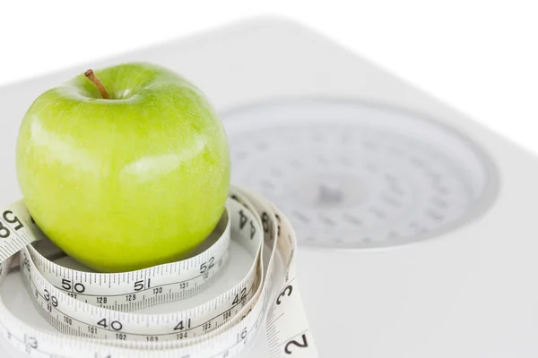 Primo piano di una mela verde cerchiata con un metro a nastro e pesatura — Foto Stock