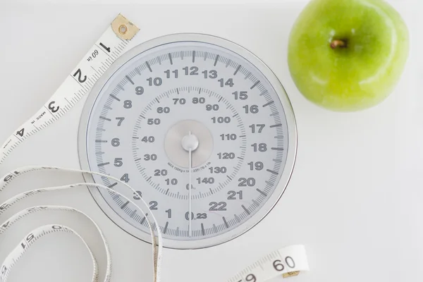Vista superior de una manzana verde junto con una cinta métrica y un peso - —  Fotos de Stock