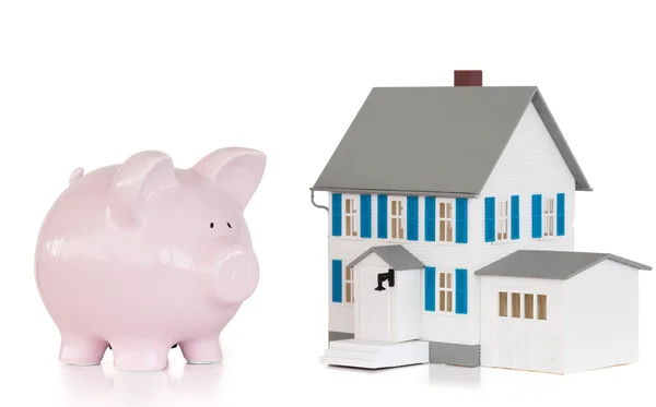 Huis en roze piggy bank — Stockfoto