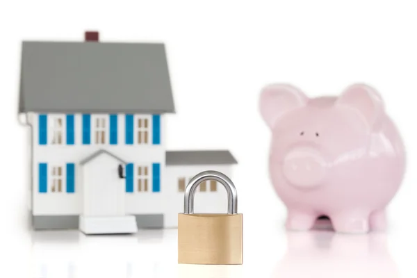 House locked with padlock and piggy bank — Stock Photo, Image