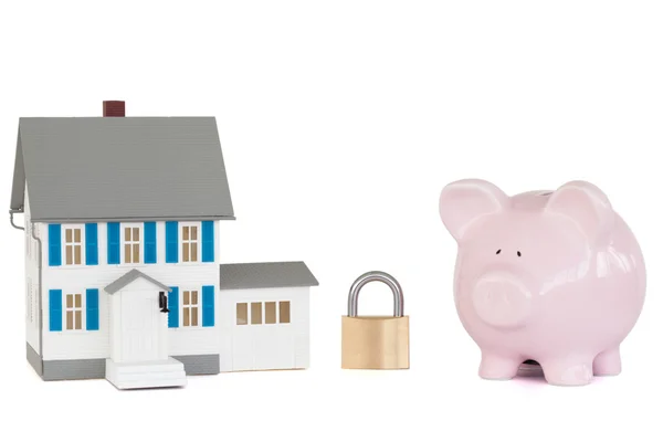 Huis vergrendeld met hangslot en roze piggy bank — Stockfoto