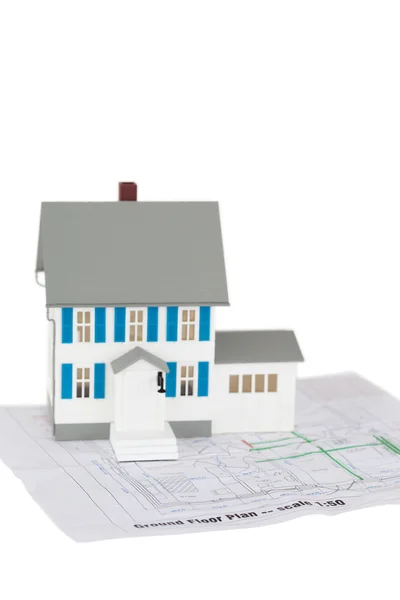 Grey toy house model on a ground floor plan — Stock Photo, Image