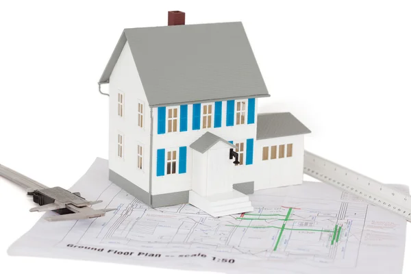 Closeup of toy house model and caliper on a ground floor plan — Stock Photo, Image