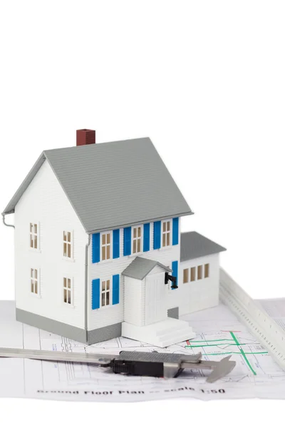 Toy house model and caliper on a ground floor plan — Stock Photo, Image