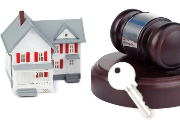 stock image Closeup of a toy house model and a brown gavel