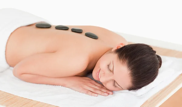 Jonge vrouw met een stenen massage — Stockfoto