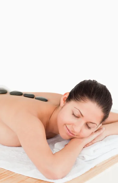 Jonge donkerharige vrouw met een stenen massage — Stockfoto