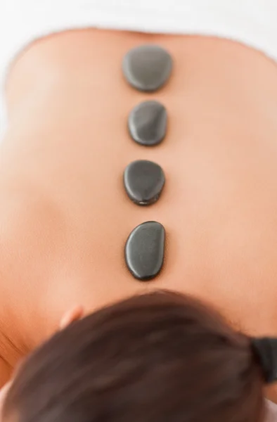 Piedras negras en la espalda de una joven — Foto de Stock