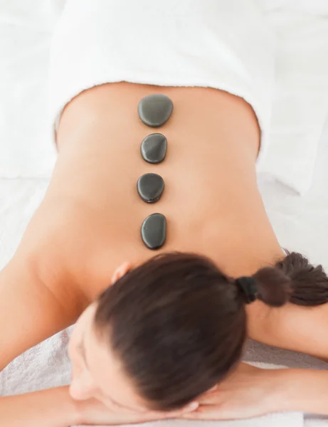 Pedras negras massagem em uma mulher de cabelos escuros — Fotografia de Stock