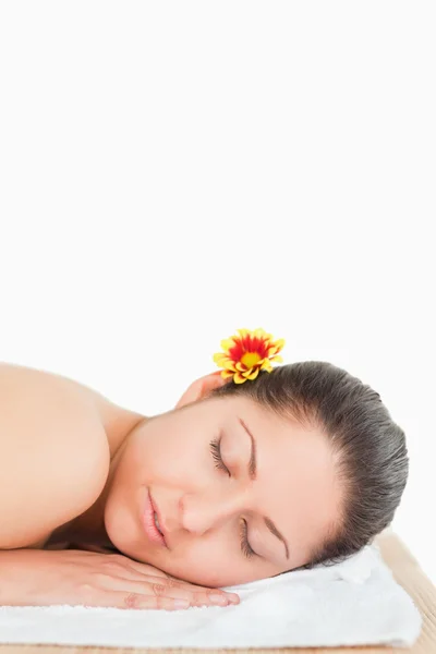 Eyes closed brunette with a flower on her ear — Stock Photo, Image