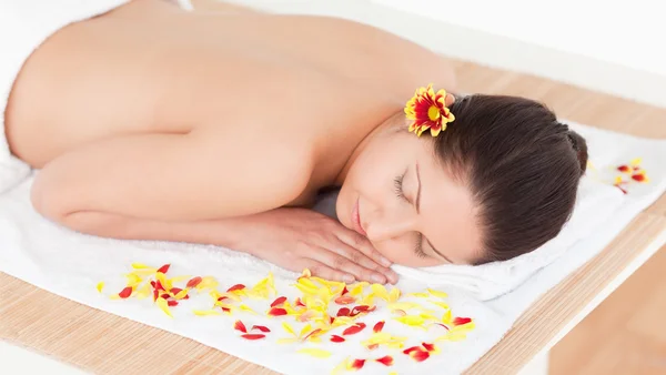 Young woman sleeping with flower petals around her — Stock Photo, Image