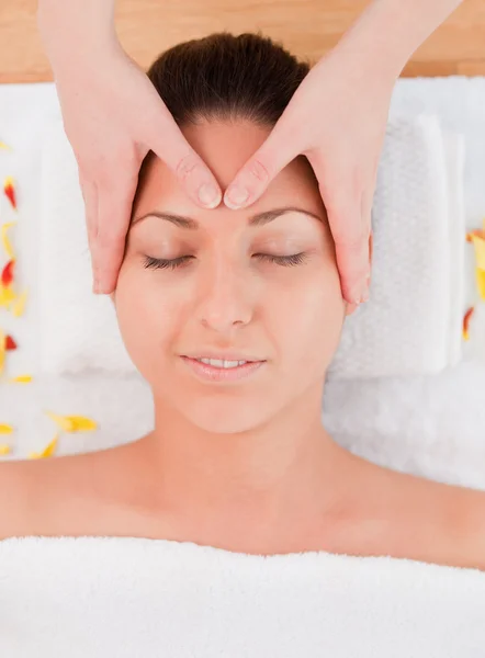 Donna dai capelli scuri che fa un massaggio alla fronte — Foto Stock