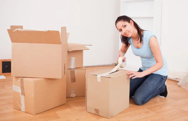 Young brunette taping a box — Stock Photo, Image