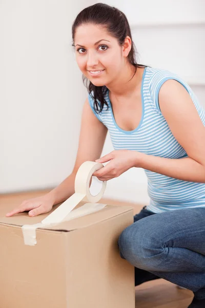 Leuke vrouw taping een doos — Stockfoto