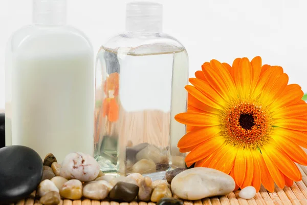Nahaufnahme von Sonnenblumen mit runden glatten Kieselsteinen und Glasflasche — Stockfoto