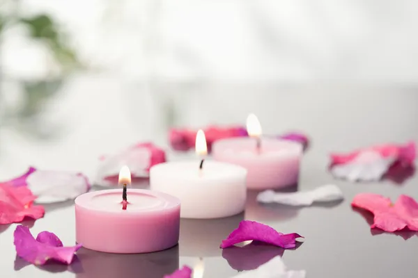 Kerzen und Blütenblätter angezündet — Stockfoto