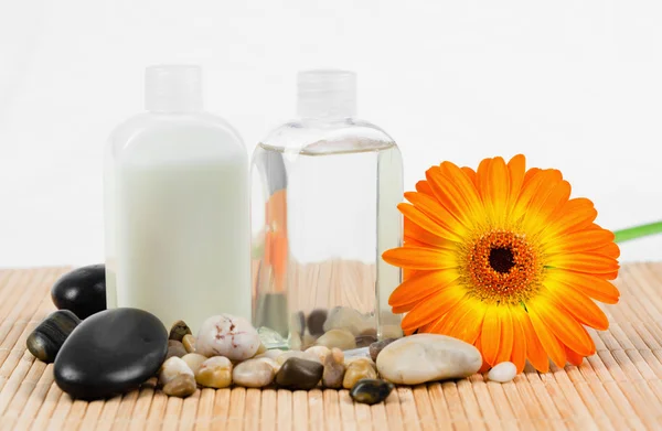 Sonnenblume mit runden, glatten Kieselsteinen und Glasflaschen — Stockfoto