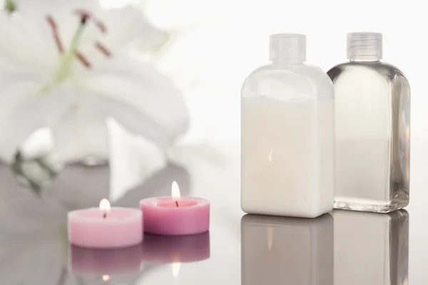 Bílá orchidej skleněné ampule a růžové zapálené svíčky — Stock fotografie